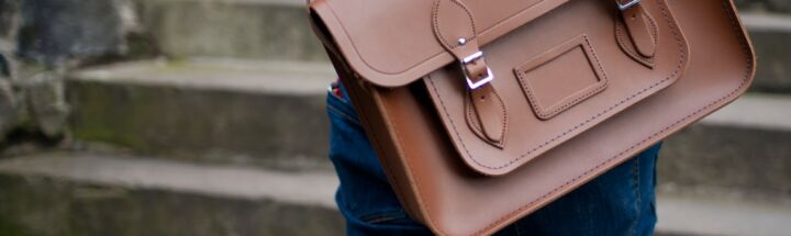 person carrying brown leather shoulder bag