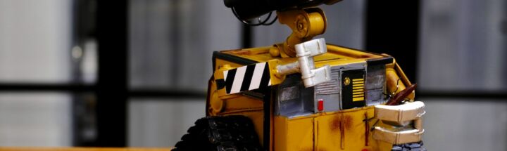 yellow and black Wall-E toy on brown wooden table
