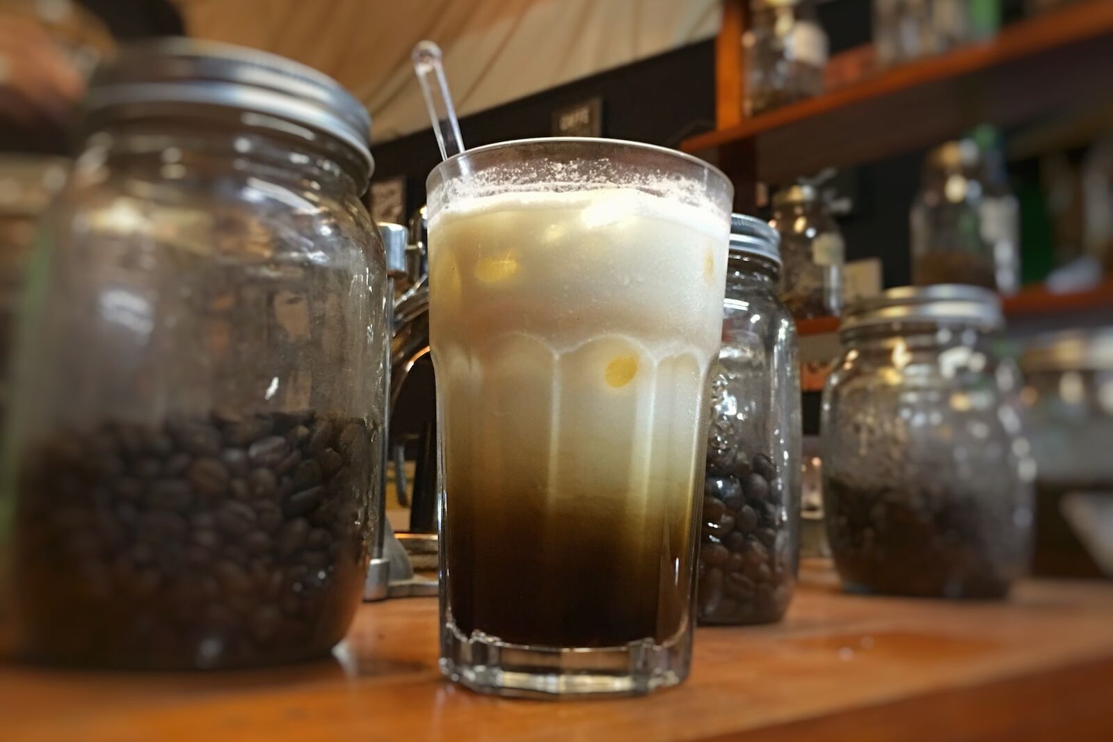 clear drinking glass next to two glass jars