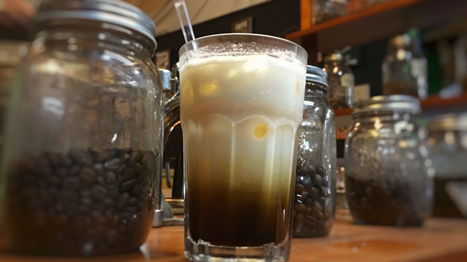 clear drinking glass next to two glass jars