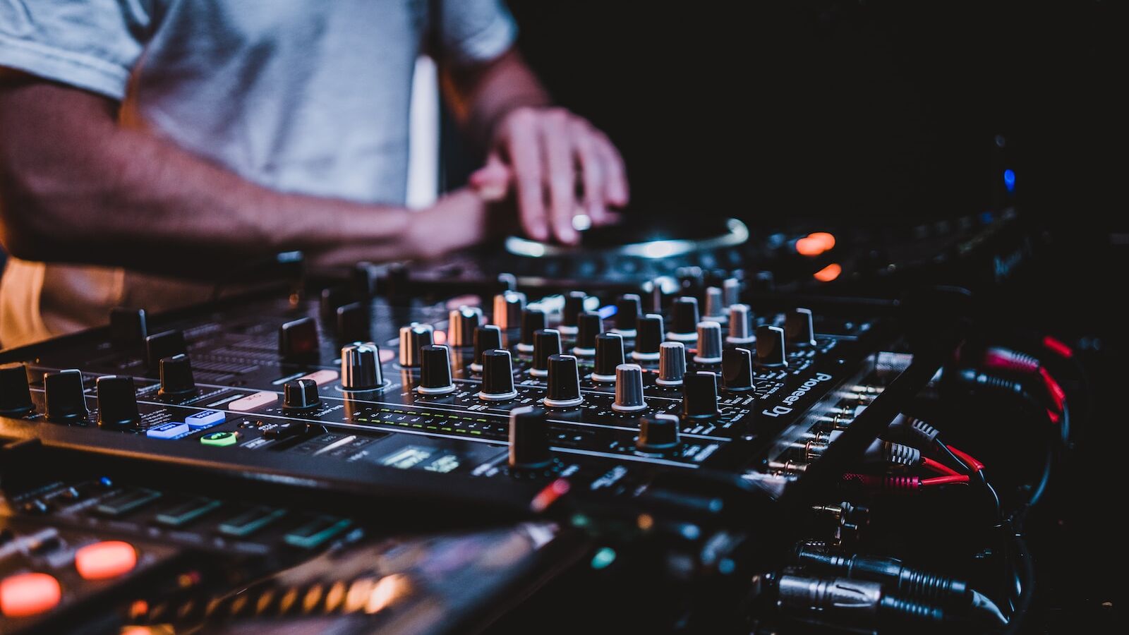 person in gray shirt playing audio mixer