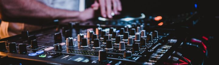 person in gray shirt playing audio mixer