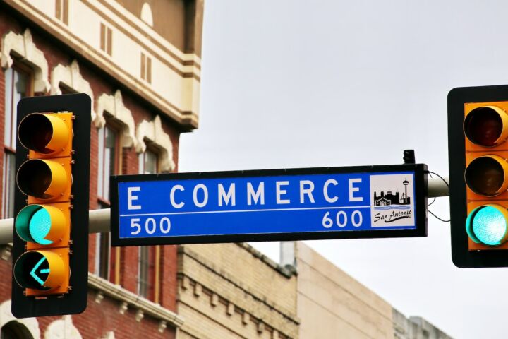 a traffic light with a street sign hanging from it's side