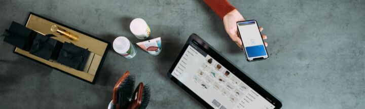 person holding smartphone beside tablet computer