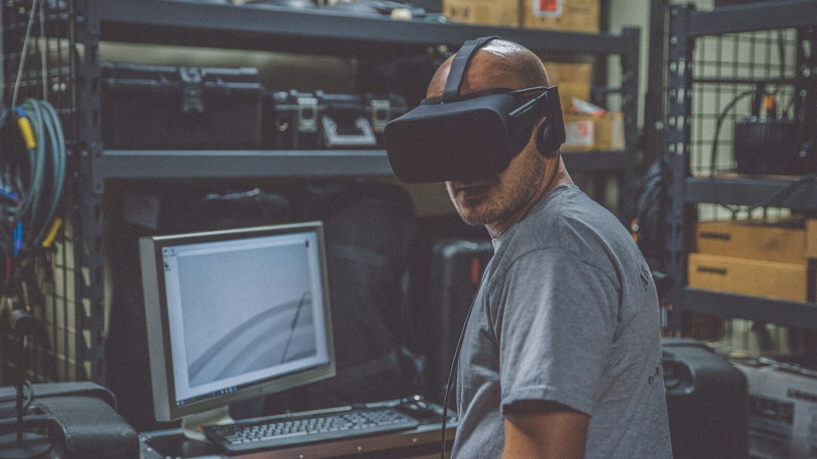 person using black VR Headset in front of computer