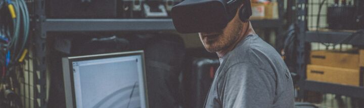 person using black VR Headset in front of computer