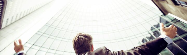 low-angle photography of man in the middle of buidligns