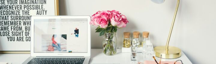 MacBook Air beside gold-colored study lamp and spiral books