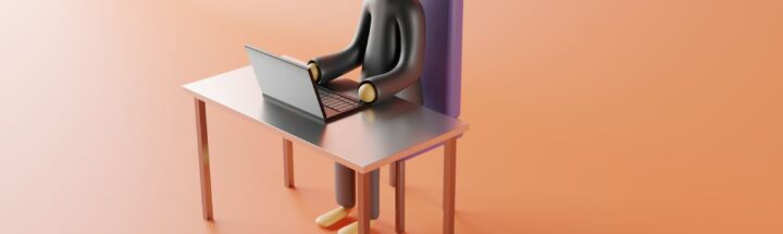a person sitting at a desk with a laptop on it