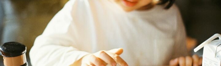 woman in white long sleeve shirt holding black smartphone