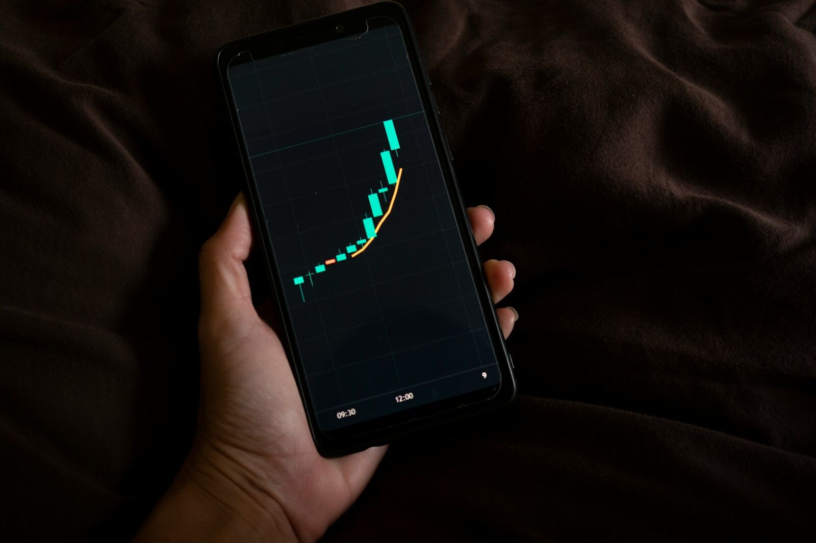 a person holding a cell phone with a chart on the screen