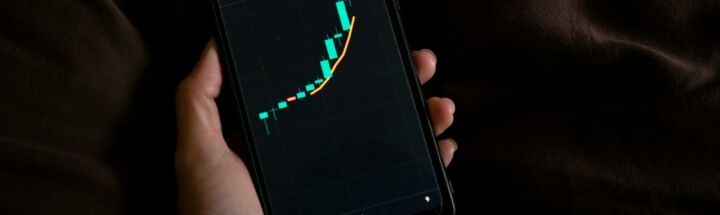 a person holding a cell phone with a chart on the screen