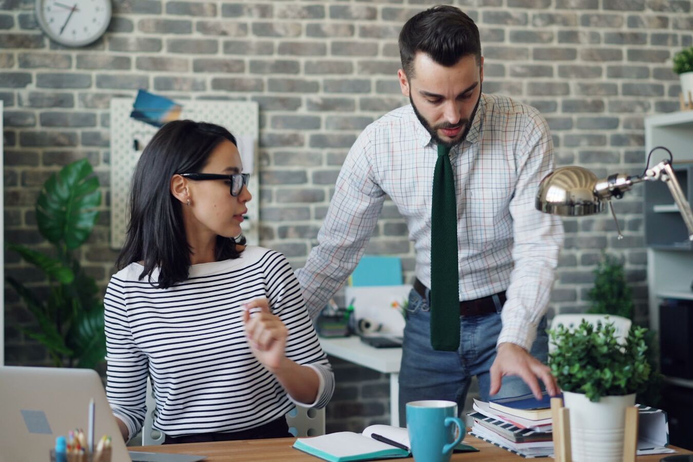 a man and a woman standing in front of a laptop