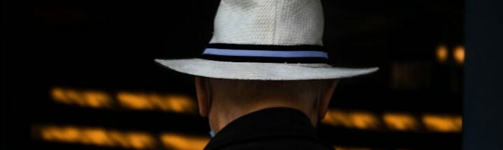 man in black suit wearing white cowboy hat