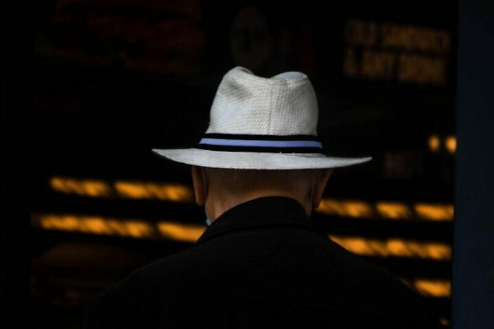 man in black suit wearing white cowboy hat