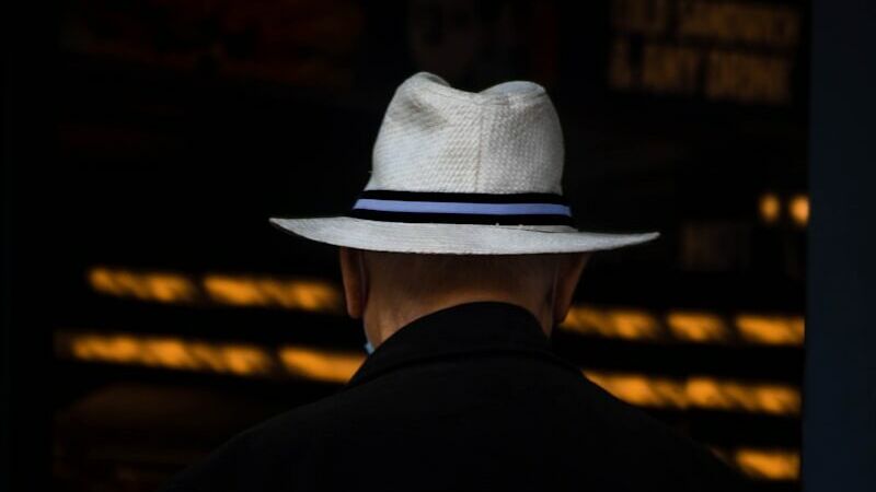 man in black suit wearing white cowboy hat