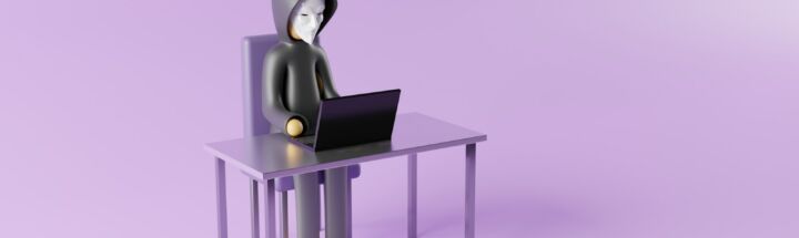 a person sitting at a desk with a laptop on it