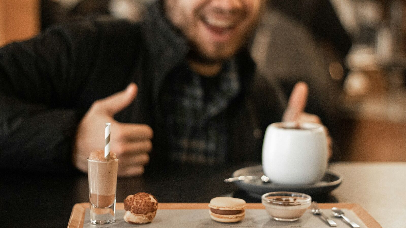 selective focus photography of smiling man in front of tray with pastries