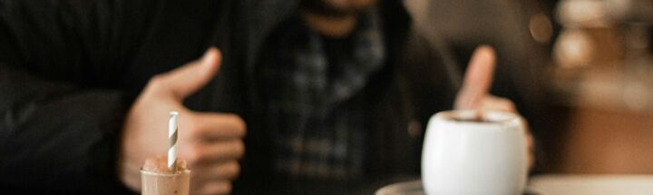 selective focus photography of smiling man in front of tray with pastries