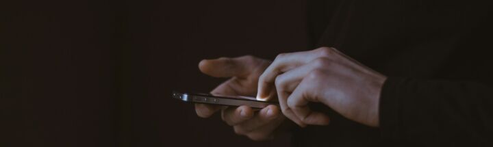 silhouette photo of person holding smartphone