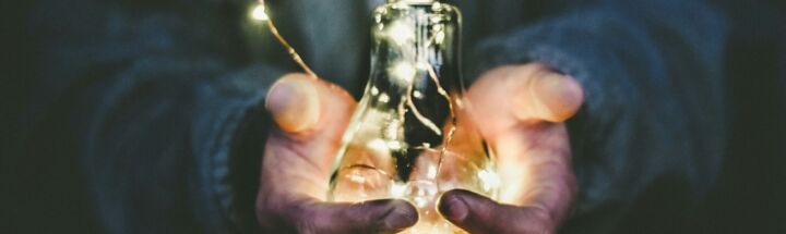 man holding incandescent bulb