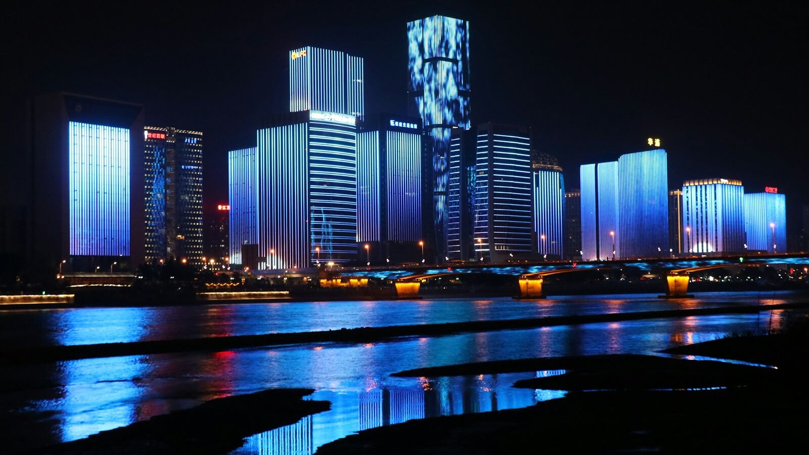 photography of lighted buildings reflecting on water
