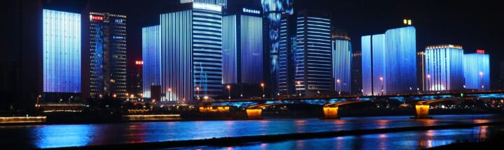 photography of lighted buildings reflecting on water