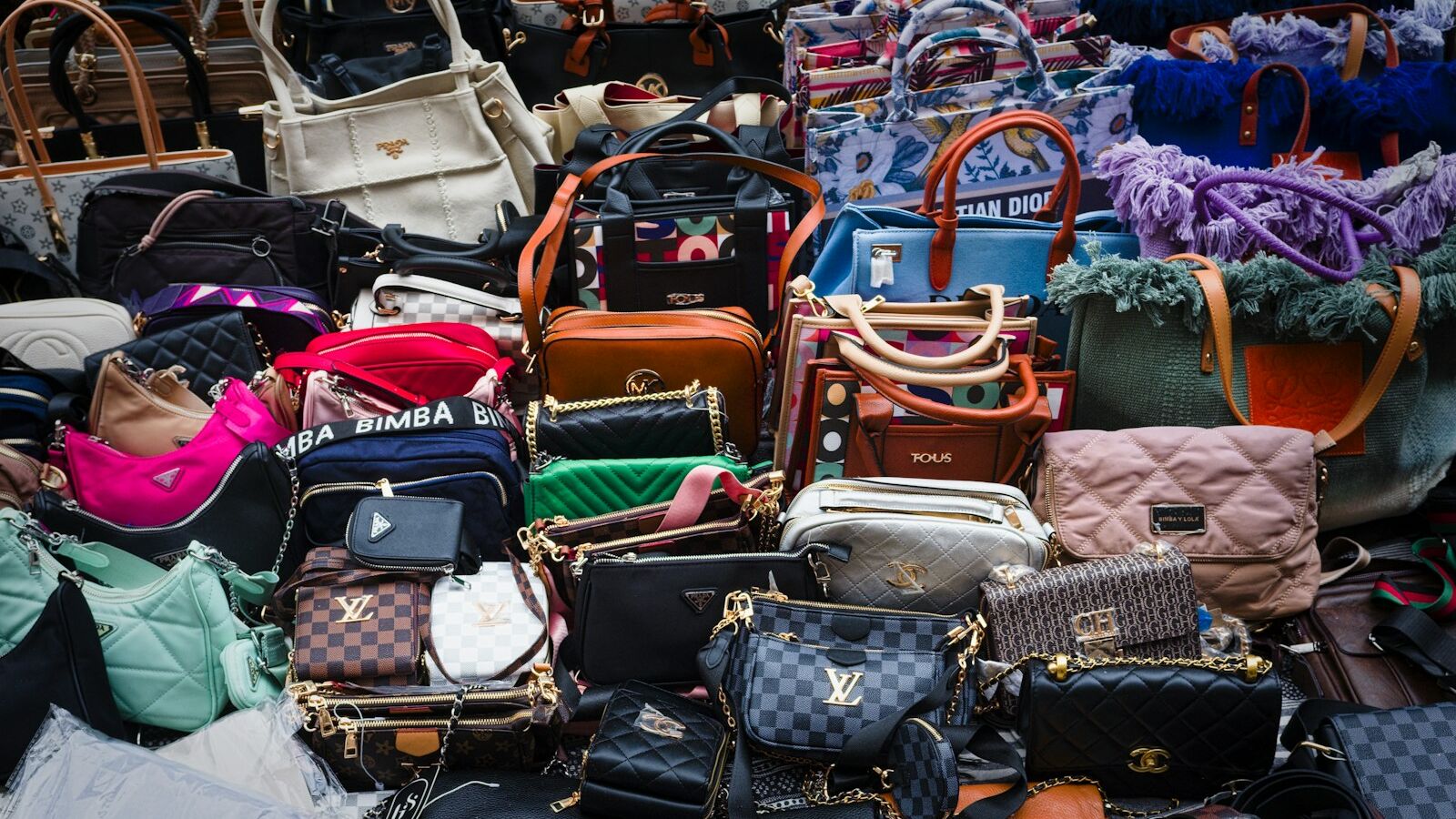a pile of purses and handbags sitting next to each other