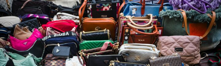 a pile of purses and handbags sitting next to each other