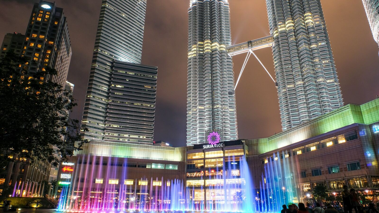people walking on street near high rise buildings during night time