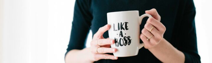 woman holding white mug while standing