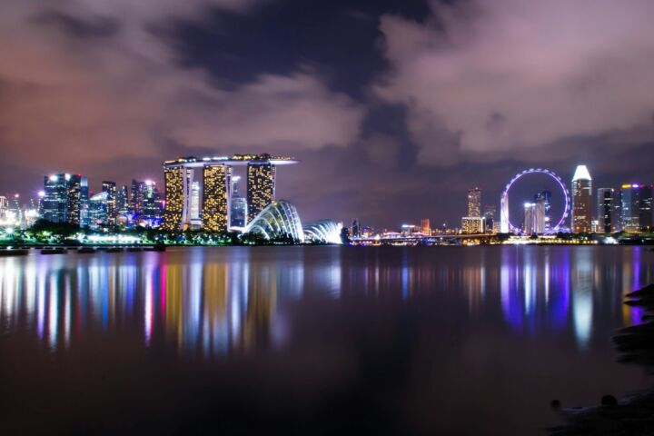 A view of a city at night with a ferris wheel in the distance