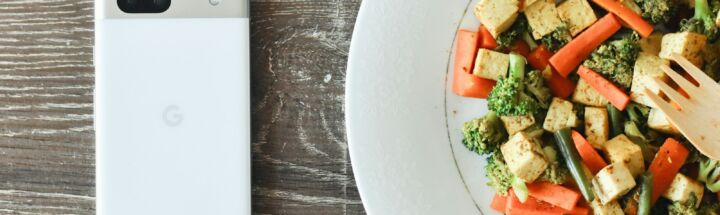 a plate of food with a cell phone next to it