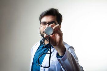 person in white shirt holding black and silver headphones