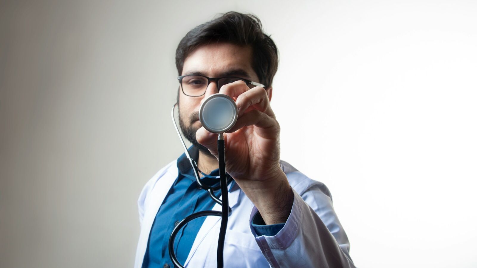 person in white shirt holding black and silver headphones