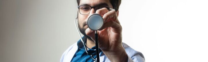 person in white shirt holding black and silver headphones