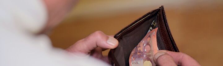 a man holding a wallet in his left hand
