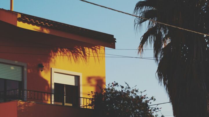 yellow concrete house beside tree