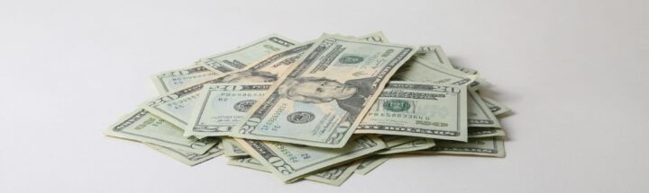 a pile of money sitting on top of a white table