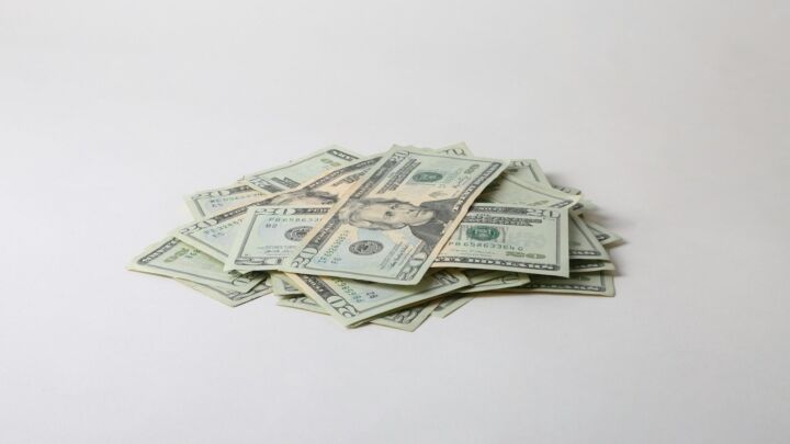 a pile of money sitting on top of a white table