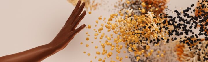 a hand reaching for a pile of seeds