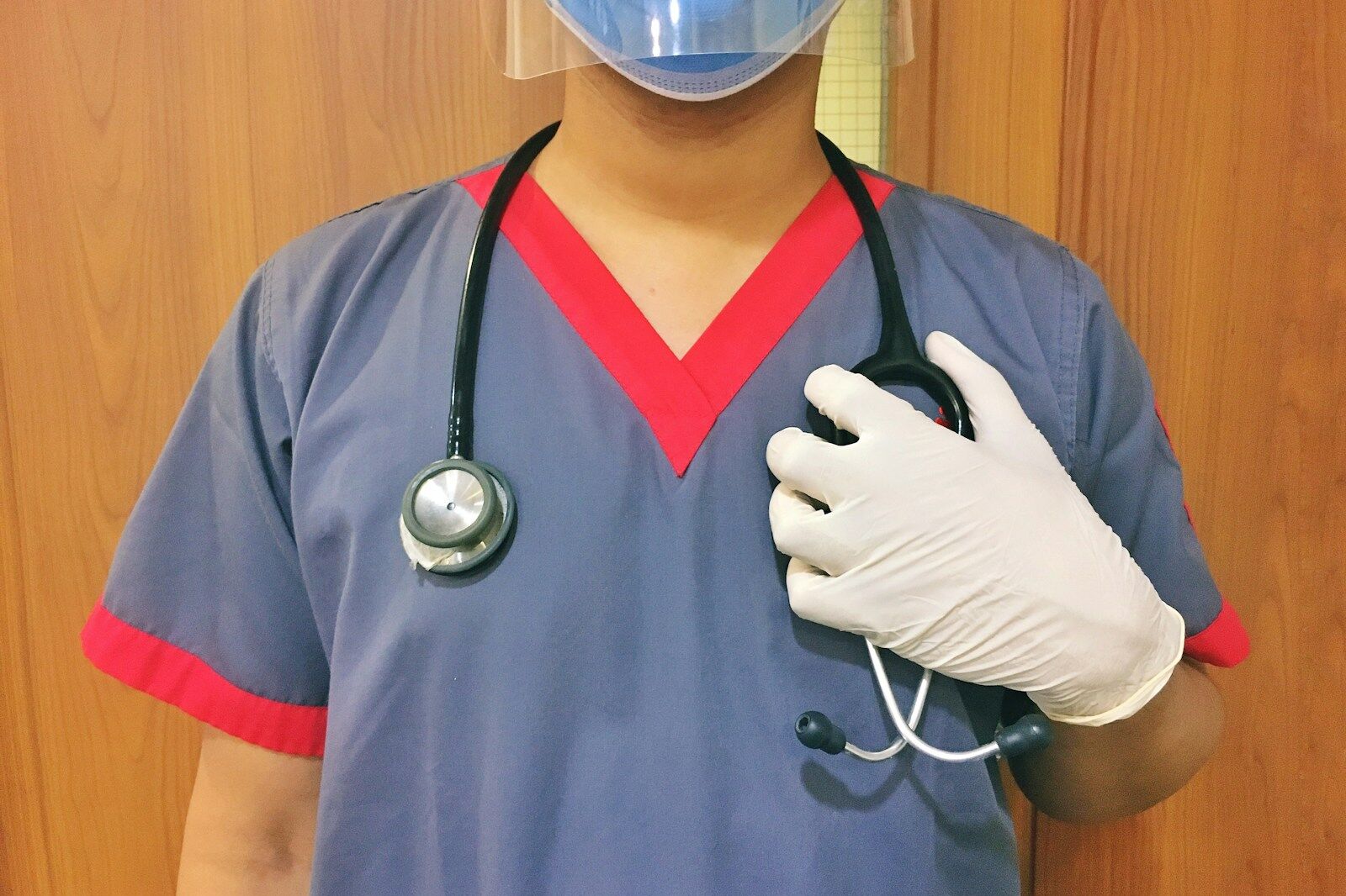 woman in blue scrub suit wearing white mask