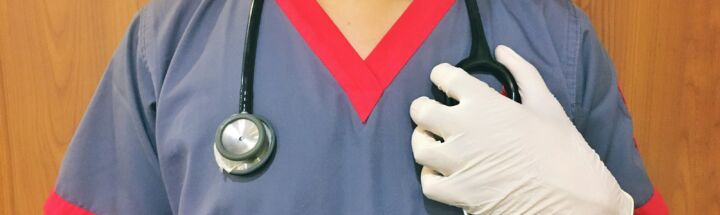 woman in blue scrub suit wearing white mask