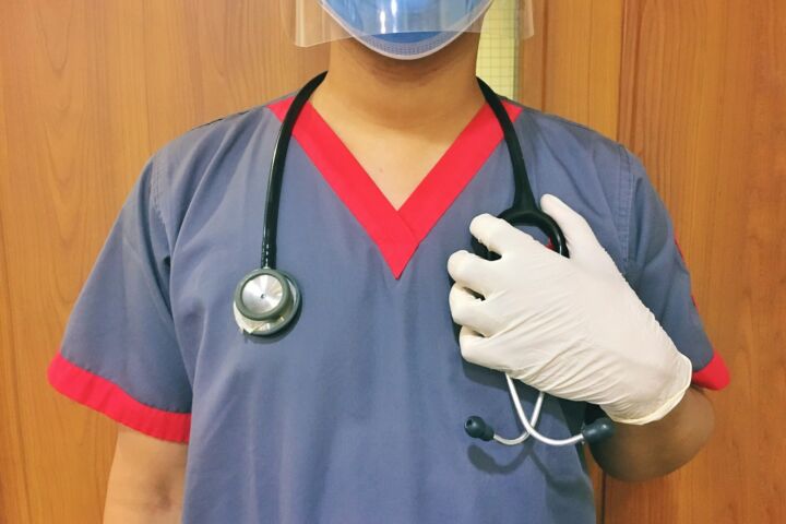 woman in blue scrub suit wearing white mask