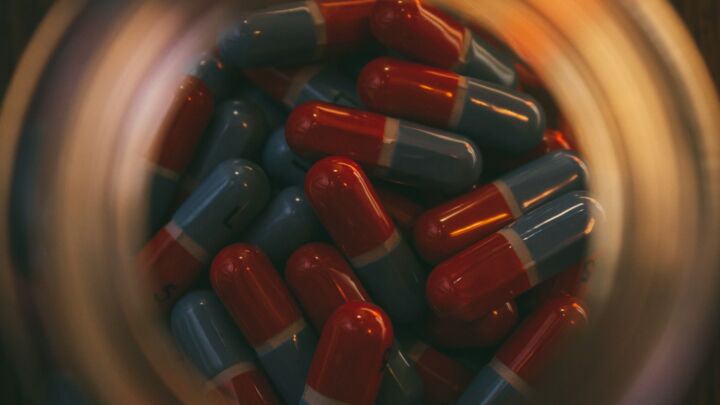 a glass jar filled with red and blue pills