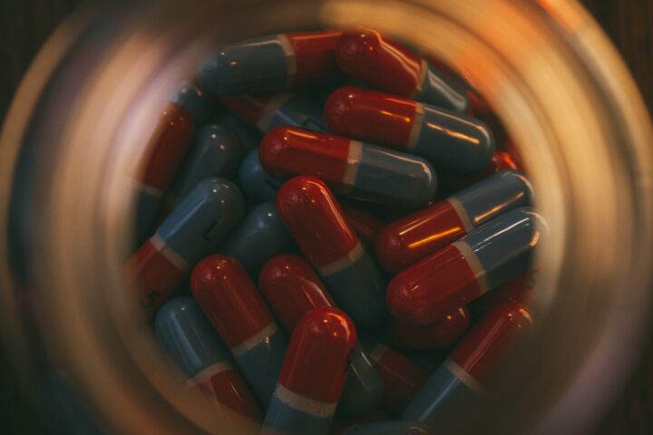 a glass jar filled with red and blue pills