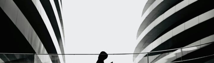 A person standing on a bridge with a large american flag in the background