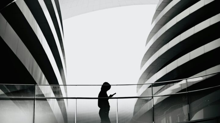 A person standing on a bridge with a large american flag in the background