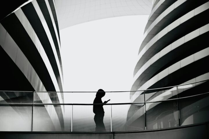 A person standing on a bridge with a large american flag in the background