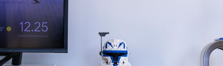 a robot toy sitting on top of a wooden shelf